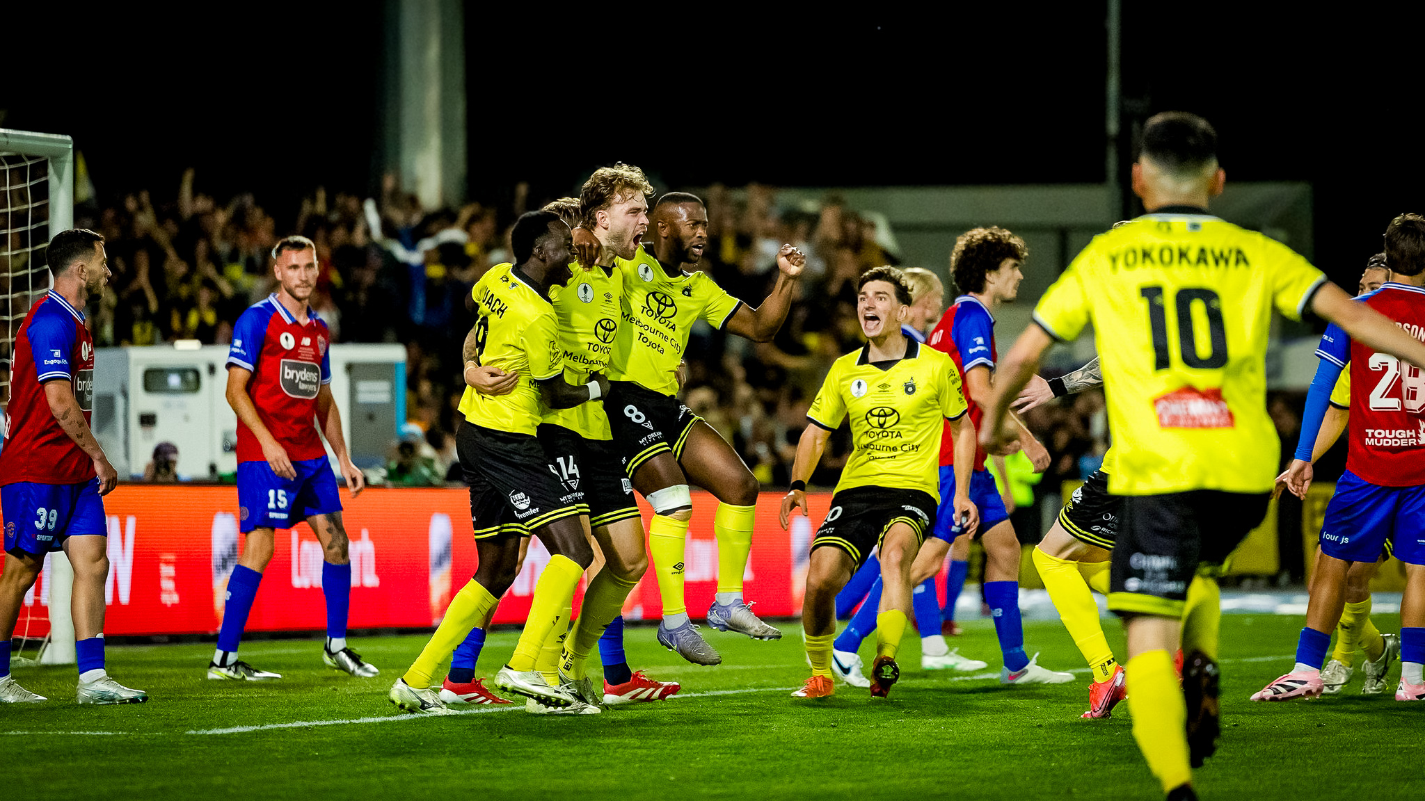 Heidelberg United players celebrating after a goal during their Australia Cup run, showcasing Victorian football disruption